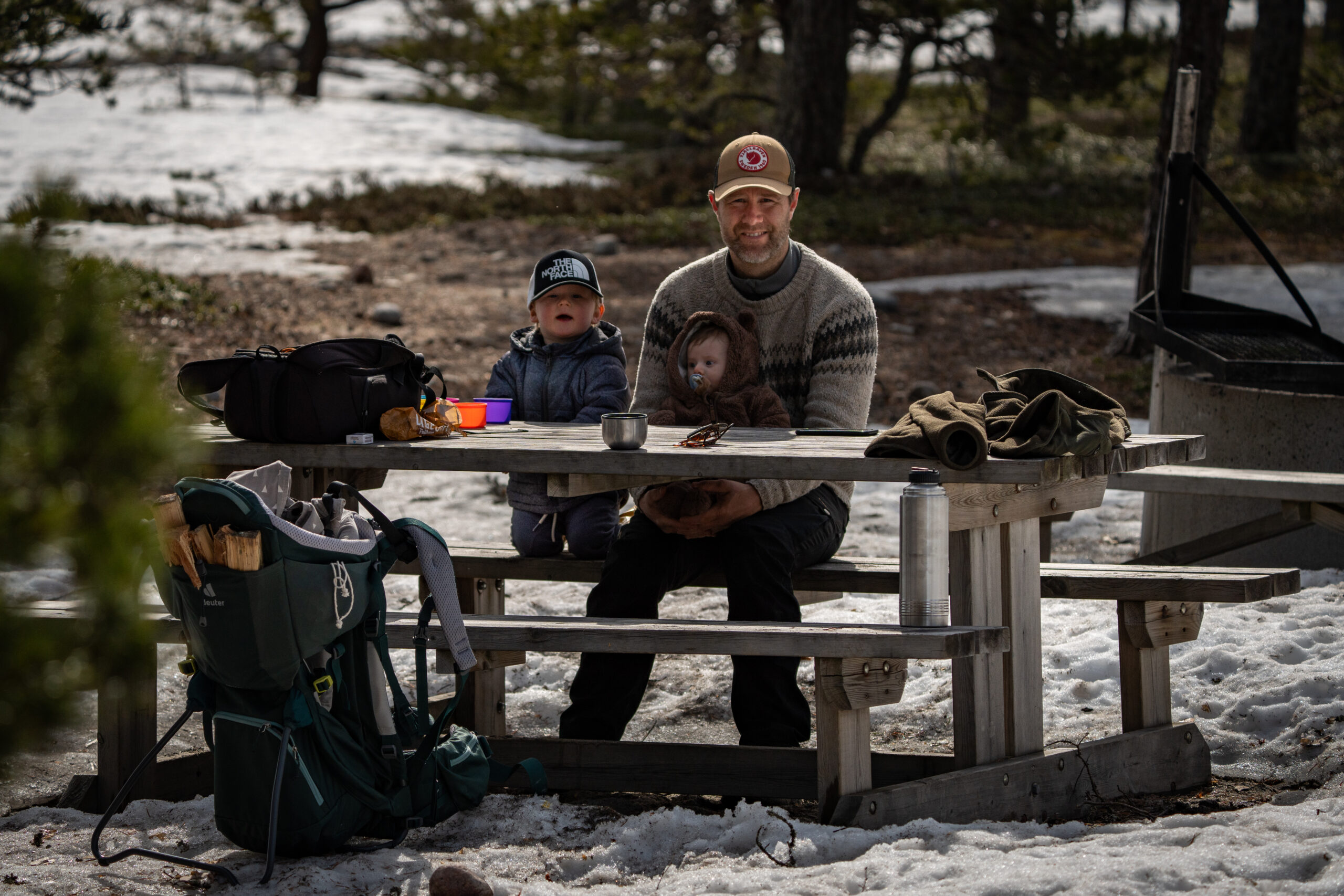 Een gezin aan een picknicktafel. Buitenleven in Zweden