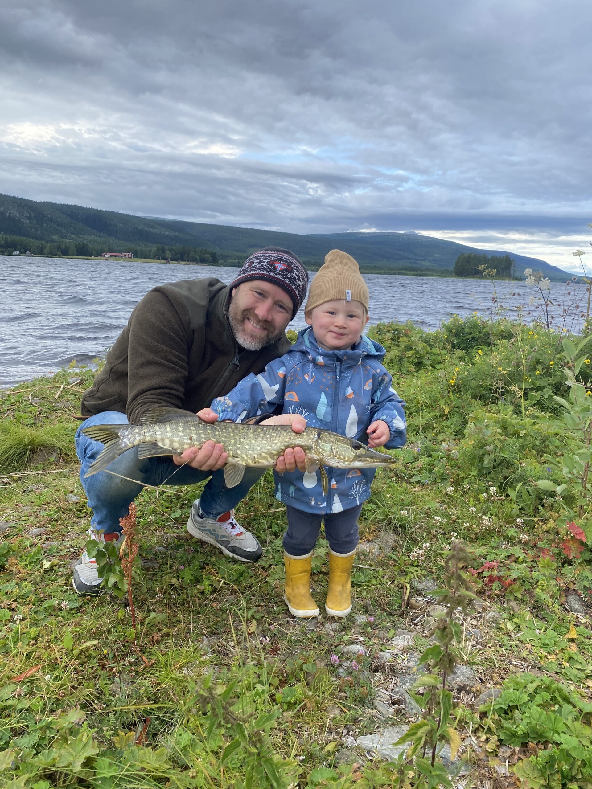 Vader en zoon hebben een vis gevangen op vakantie in Zweden