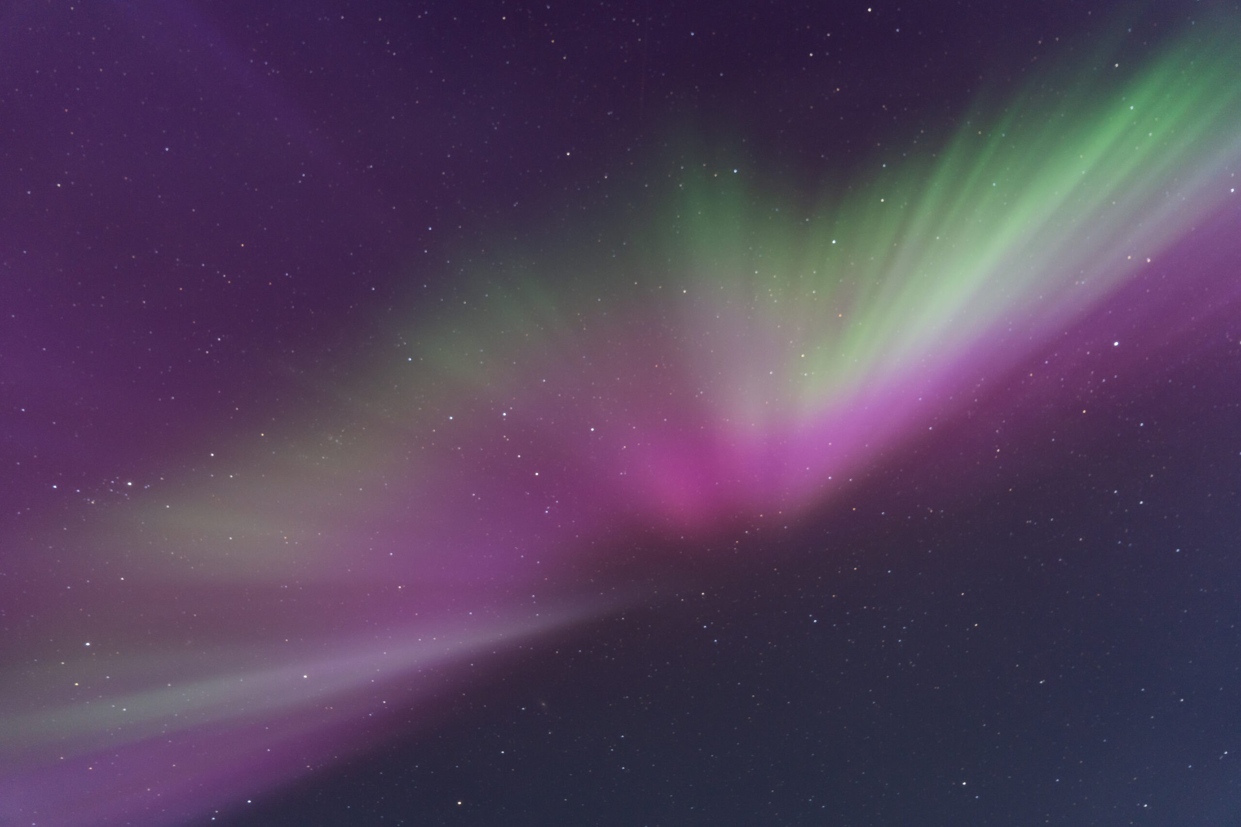 Noorderlicht. De lucht is groen, paars en en rood gekleurd.