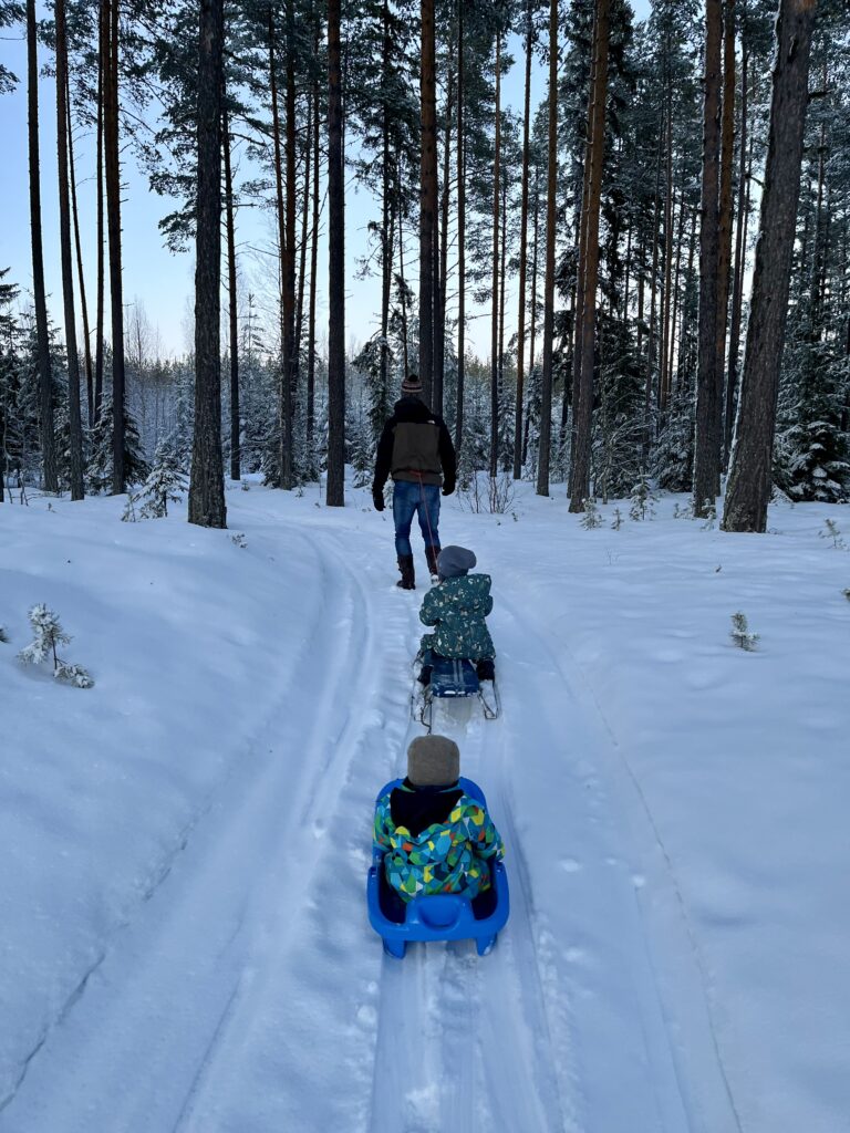 Twee kinderen aan het sleeën in de winter in Zweden bij Friluft Sweden