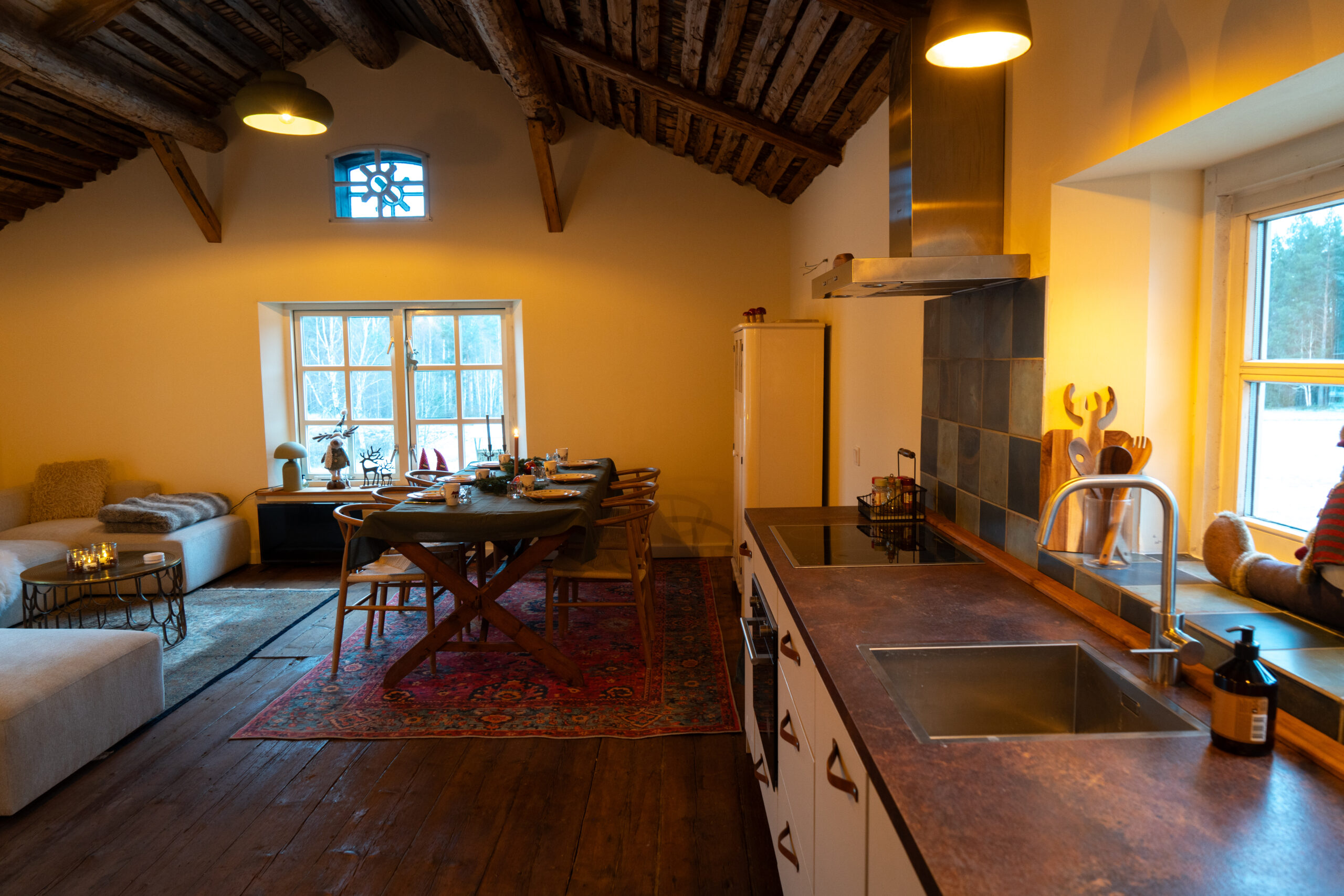 Het sfeervolle vakantiehuis van Friluft Sweden. De woonkeuken met eettafel en gezellige zithoek.