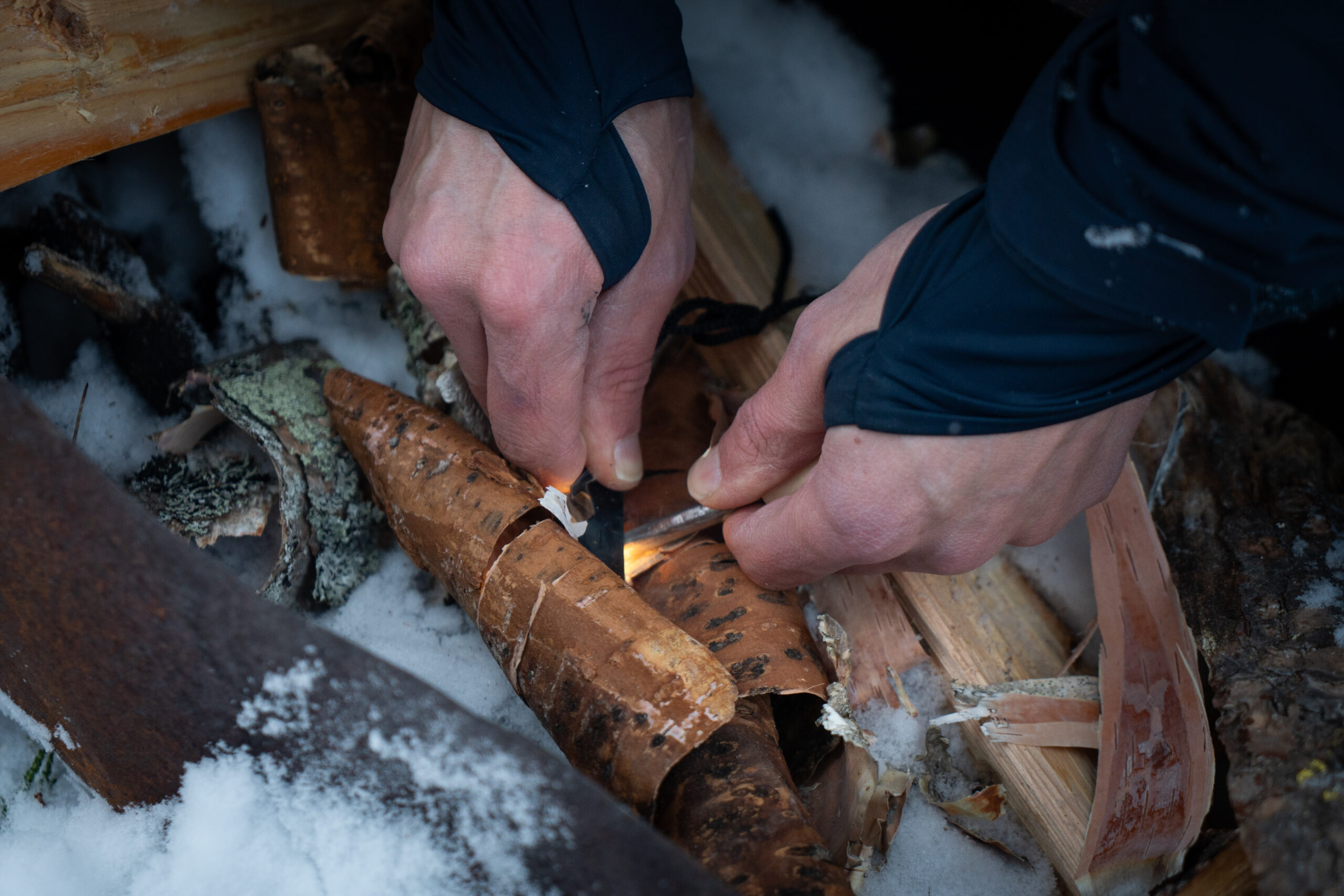 Vuur maken met een firesteel in de winter in Zweden bij Friluft Sweden