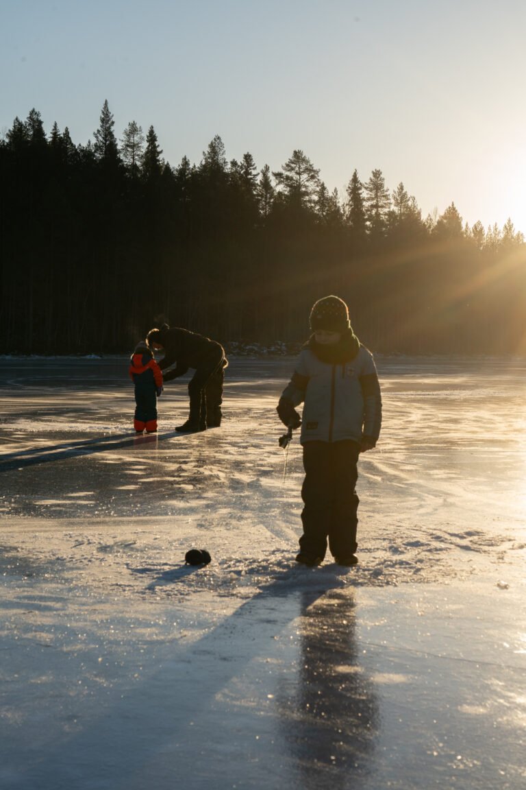 Kinderen zijn als activiteit aan het ijsvissen op het bevroren meer in Zweden bij Friluft Sweden